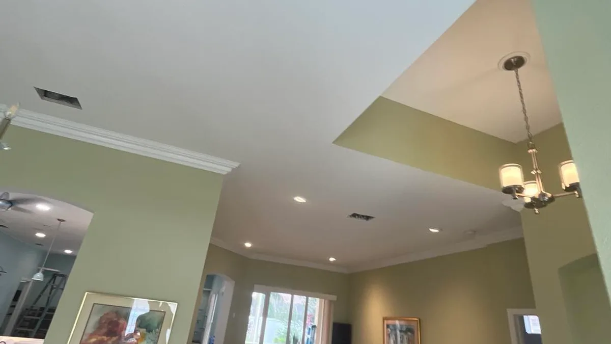 Green painted living room with white ceiling and trim